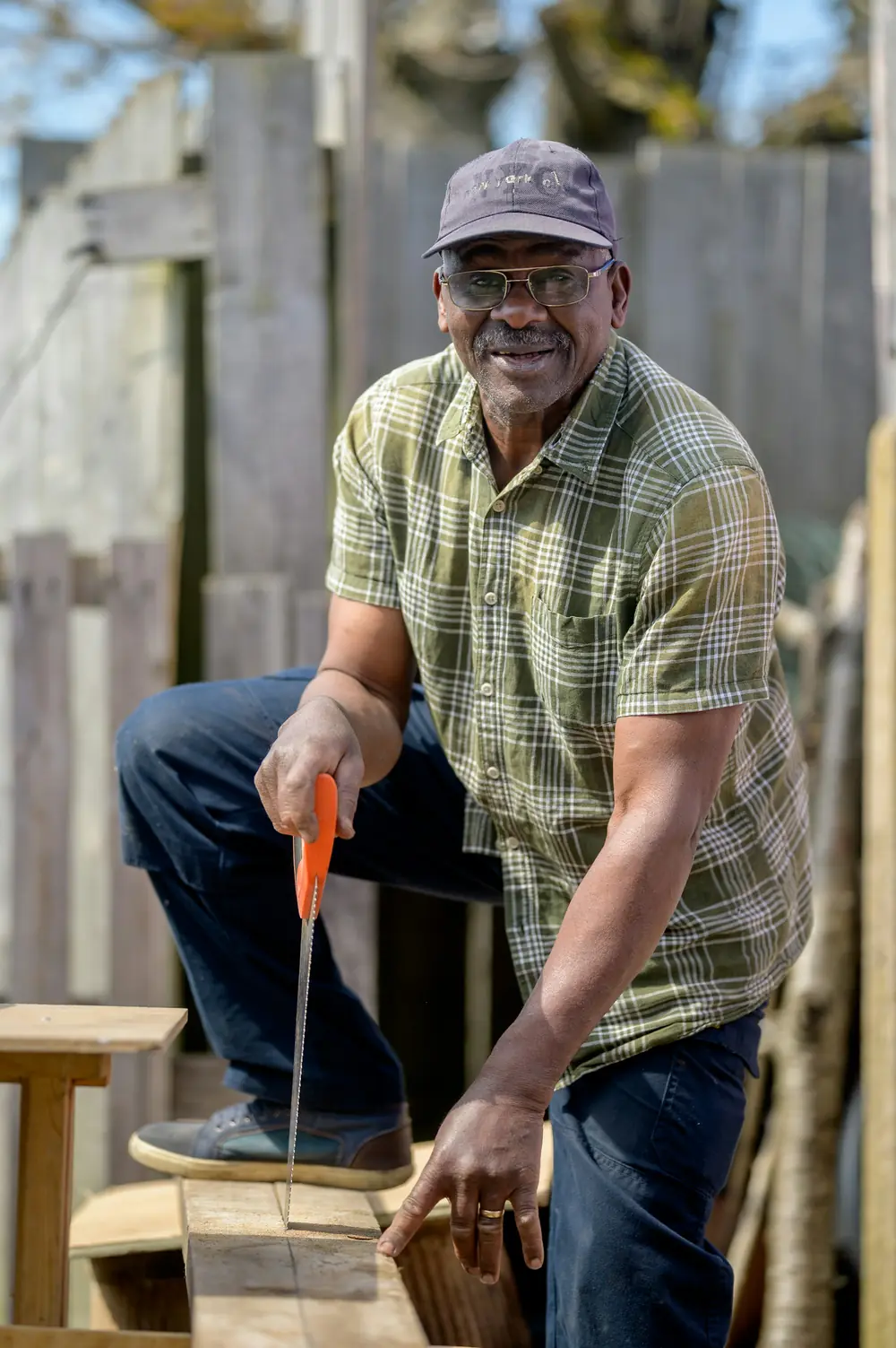 Un artisan souriant, outil en main