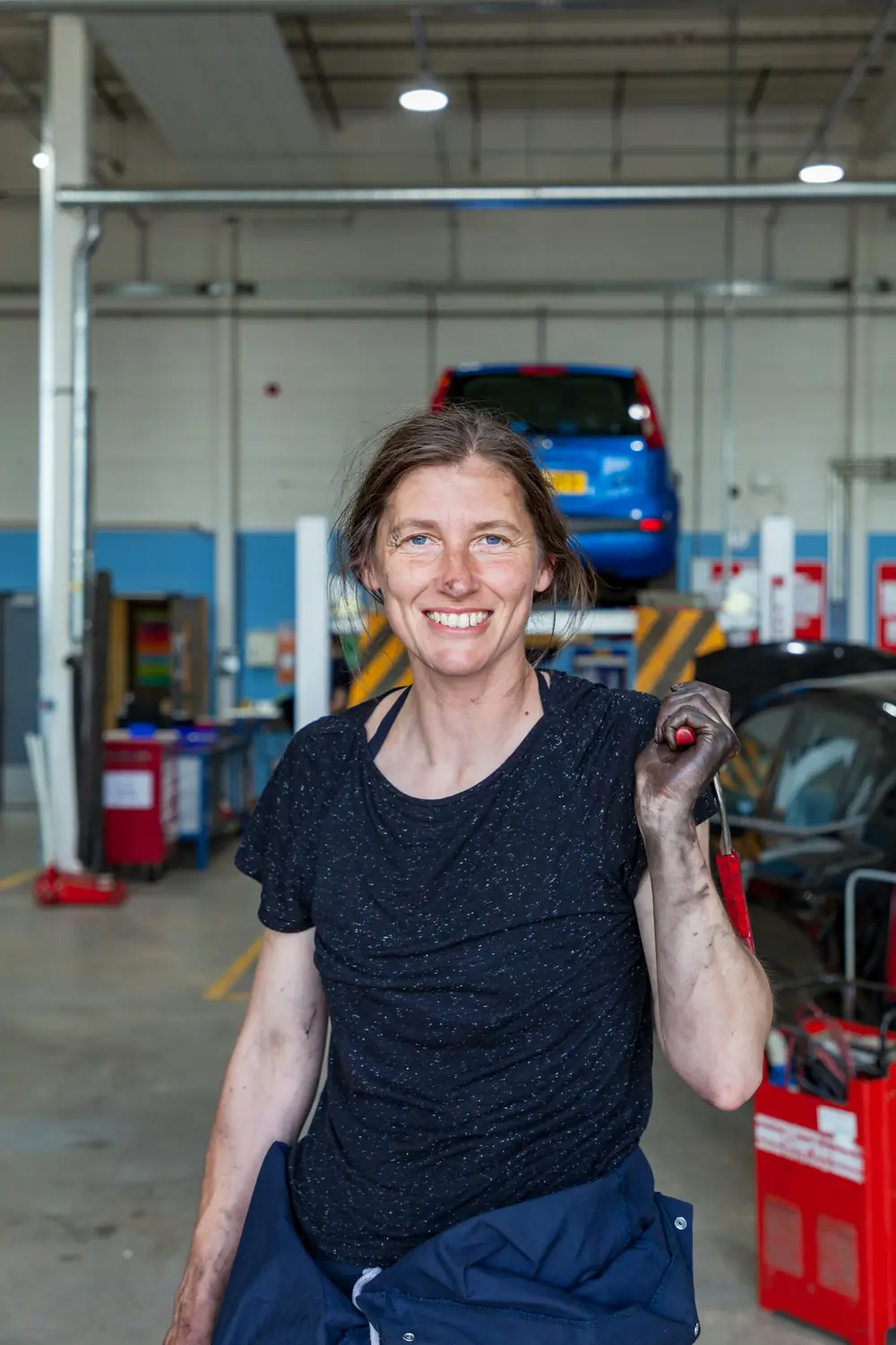 Une mécanicienne souriante dans son garage